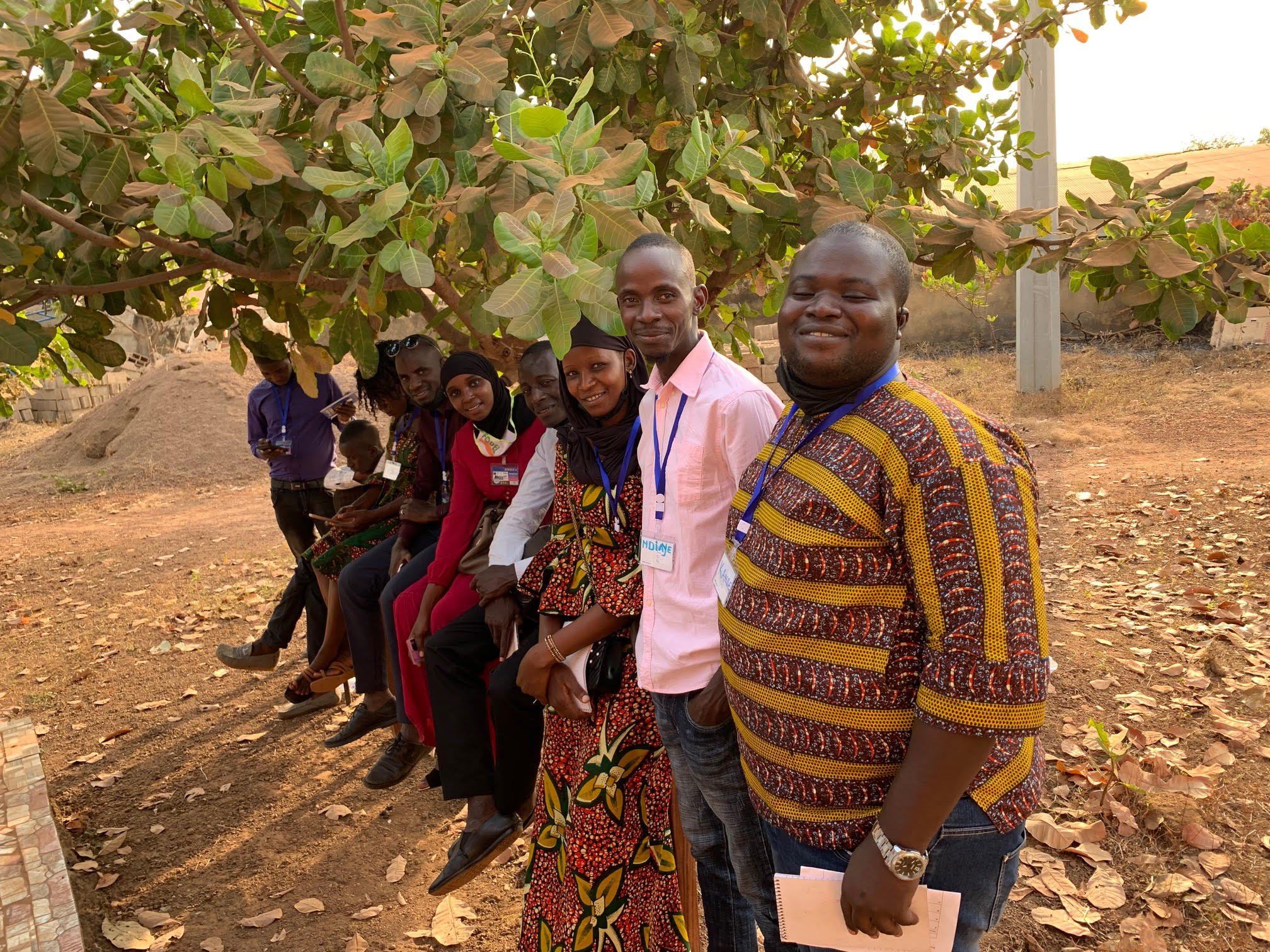 Youth advisory council members from Guinea standing under a large leafy tree